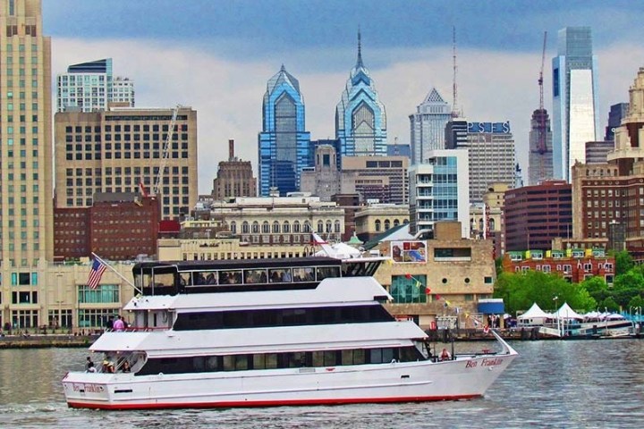 a large boat in a body of water with a city in the background