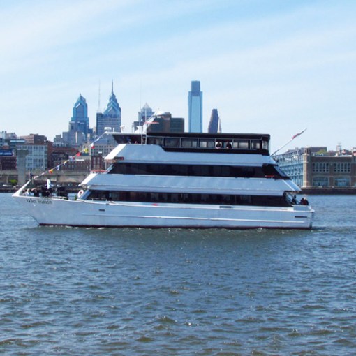 a large ship in a body of water with a city in the background