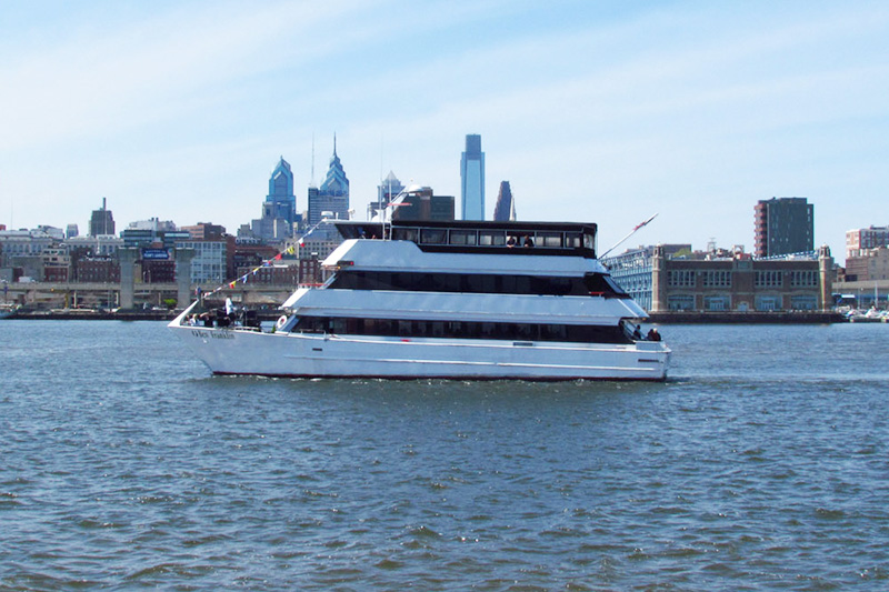 a large ship in a body of water with a city in the background